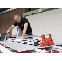 Artisan travaillant avec un coupe-carrelage pour couper un carreau à la taille voulue