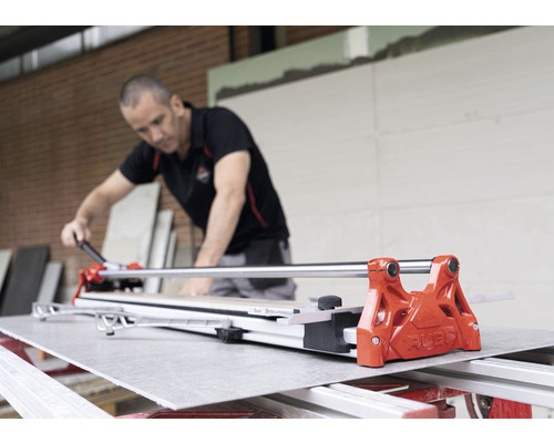 Artisan travaillant avec un coupe-carrelage pour couper un carreau à la taille voulue