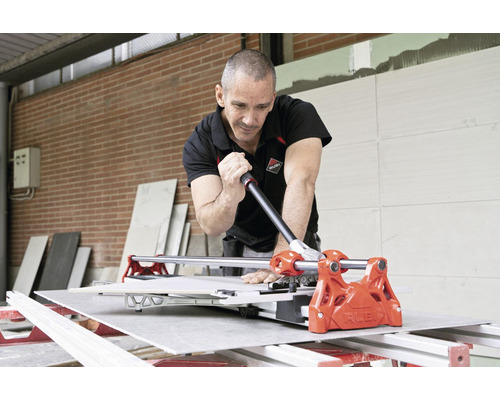 Artisan coupant des carreaux avec un coupe-carreaux