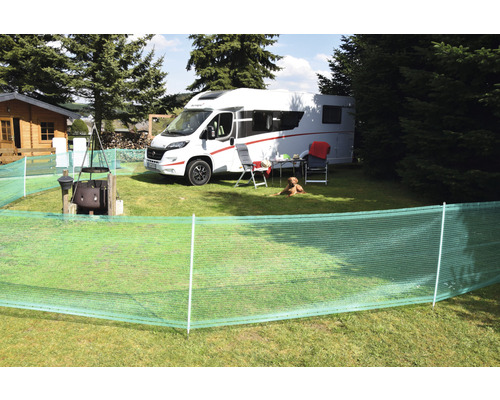 Campingplatzszene mit Wohnwagen, Sichtschutz, Möbeln und Hund