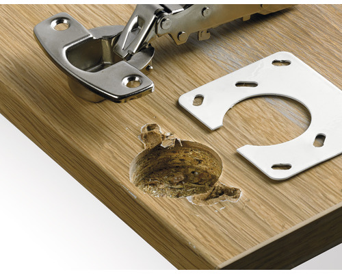 Charnière de meuble avec plaque de montage sur une surface en bois et trou de forage