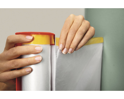 Eine Person verwendet eine Abdeckfolie mit Klebeband zum Abdecken einer Wand.