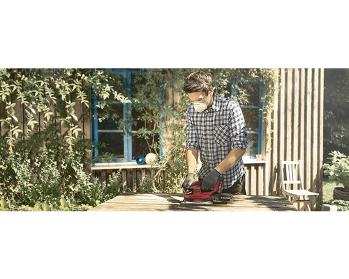 Ein Mann schleift Holz mit einem Elektroschleifer im Freien