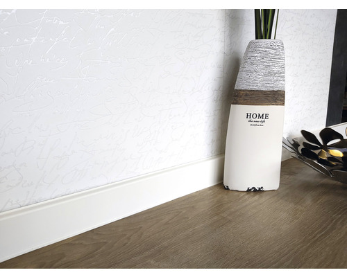 Scène avec plinthe, papier peint et décorations sur un plancher en bois