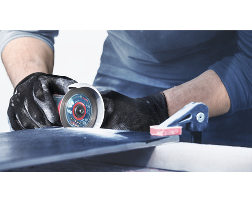 Artisan coupant un carreau avec une meuleuse d''angle