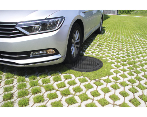 Auto auf Rasengittersteinen mit Kanaldeckel