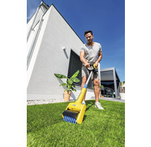 Un homme utilise une brosse à joints dans le jardin
