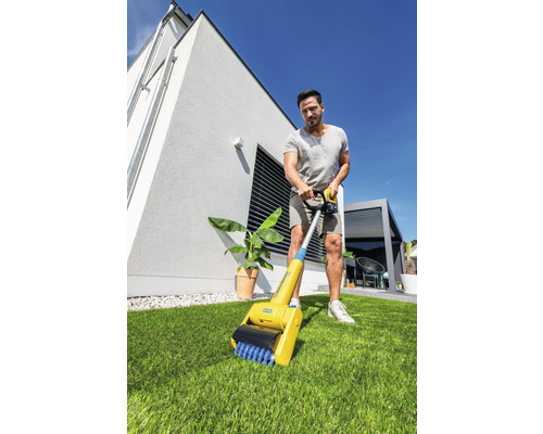 Un homme utilise une brosse à joints dans le jardin