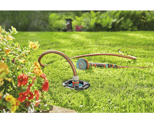 Scène de jardin avec pelouse, fleurs et arroseur oscillant escamotable