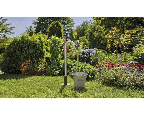Scène de jardin avec robinet d''eau et seau sur pelouse