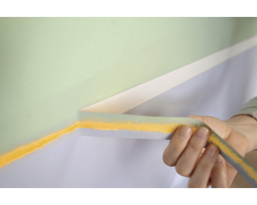 Anbringen von Malerkreppband auf einer Wand