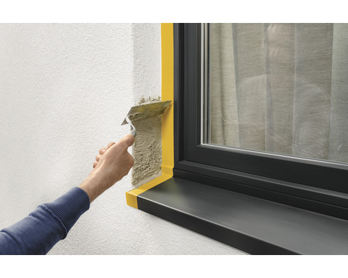 Verputzen einer Wand neben einem Fenster mit Abdeckband