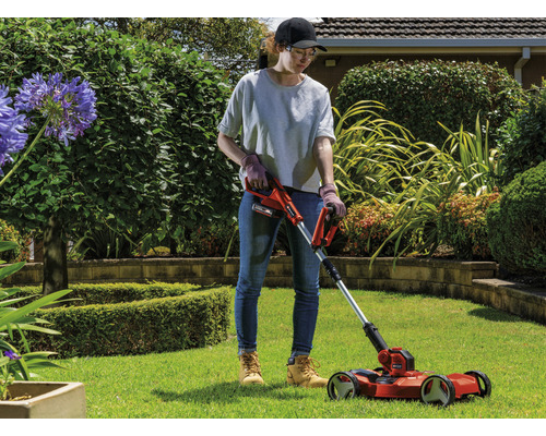Une femme utilise un coupe-bordures à batterie dans le jardin.