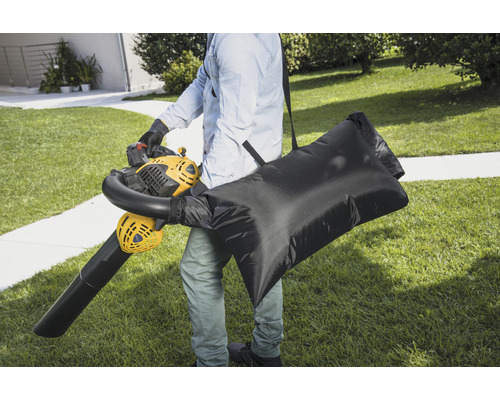 Personne avec un souffleur de feuilles et un sac de ramassage dans le jardin