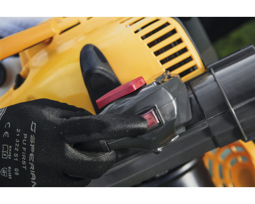 Gros plan d''un aspirateur à feuilles jaune avec une main sur l''interrupteur