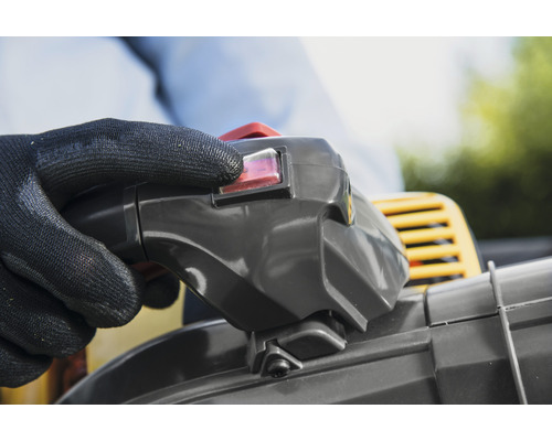 Main avec gant de protection actionnant l''interrupteur d''un souffleur de feuilles