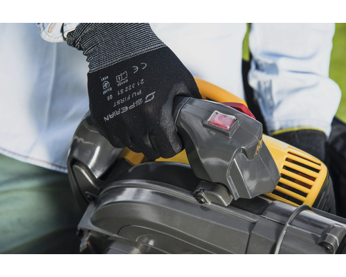 Personne utilisant un aspirateur à feuilles avec des gants de protection