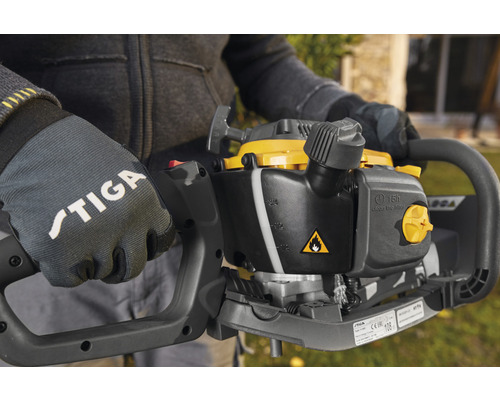 Gros plan d''une personne portant des gants Stiga tenant un taille-haie.