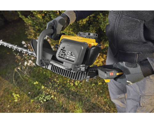 Une personne utilise un taille-haie pour tailler les haies