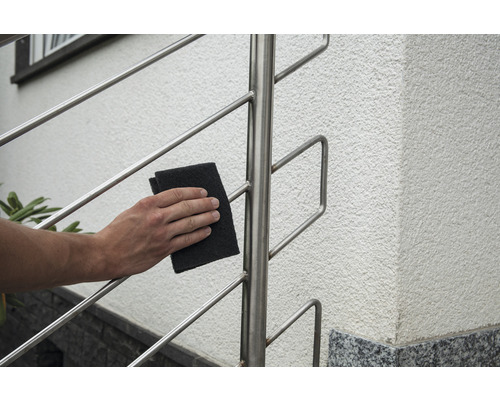 Nettoyage d''une balustrade en acier inoxydable avec un abrasif
