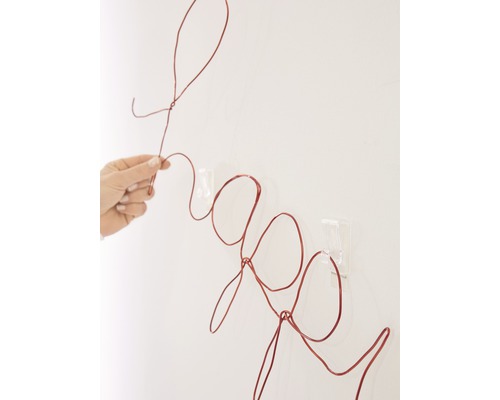 Dekorationsobjekt in Form des Wortes Frage aus Draht an der Wand befestigt