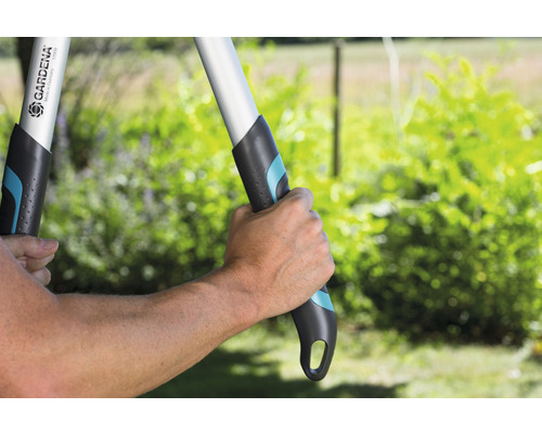 Eine Person bedient eine Astschere der Marke Gardena im Garten.