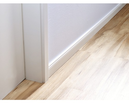 Vue détaillée d''une pièce avec sol stratifié, plinthe blanche et encadrement de porte