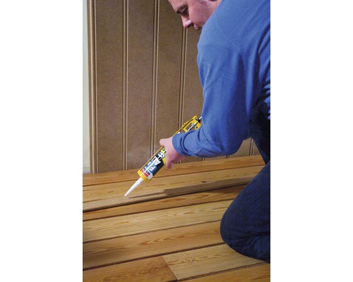 Artisan utilisant un pistolet à cartouche pour bardage bois