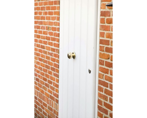 Porte blanche avec bouton de porte en laiton dans un mur en briques