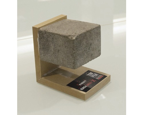 Démonstration de la force de maintien d''une colle de montage avec une pierre en béton