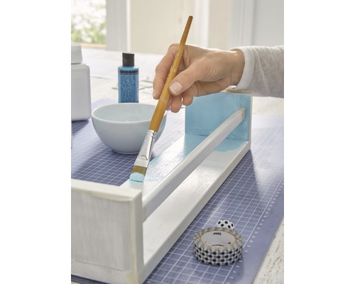 Peinture d''une étagère en bois avec un pinceau et de la peinture