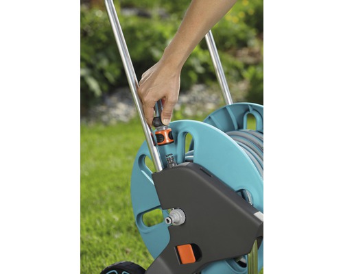 Gartenschlauchwagen mit Person, die einen Schlauchanschluss befestigt