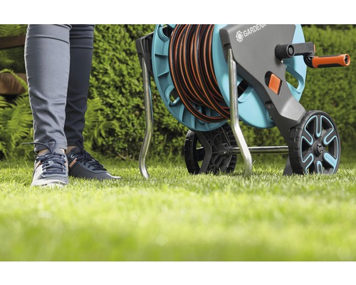 Gartenschlauchwagen mit aufgerolltem Schlauch auf Rasen