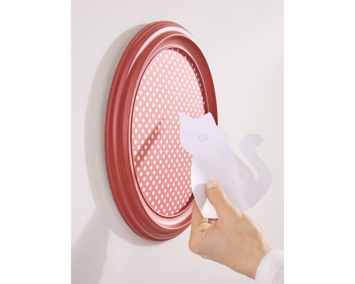 Cadre photo ovale avec fond à pois et une main appliquant un morceau de papier en forme de chat