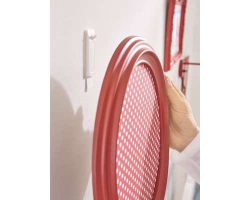 Cadre photo ovale fixé à un mur avec une bande adhésive