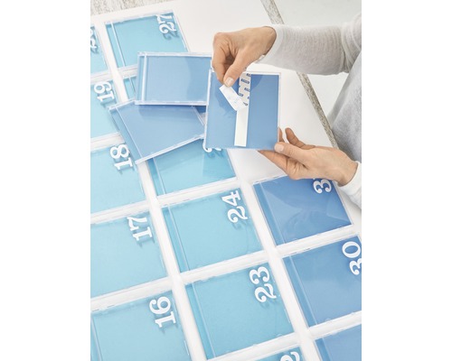 Une personne fixe une boîte de calendrier de l''avent autocollante avec des chiffres