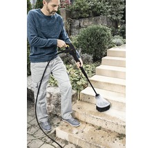 Eine Person reinigt mit einem Hochdruckreiniger eine Außentreppe.