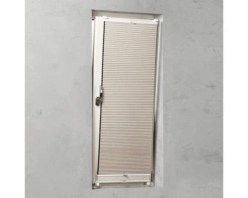 Store plissé fixé à une fenêtre.