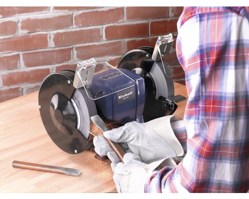 Meuleuse d''établi Einhell en cours d''utilisation pour affûter un outil dans un atelier.