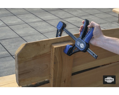 Une personne utilise une serre-joint à une main pour coller du bois