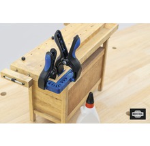 Werkbank mit Holz, Schraubzwingen und Leimflasche