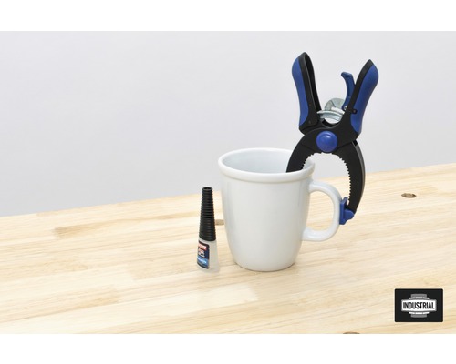 Flacon de colle, serre-joint à vis et tasse sur un établi