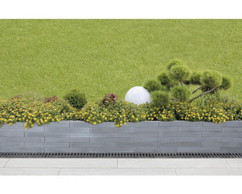 Jardin avec parterre surélevé en pierres de béton, planté de fleurs et d''arbustes d''ornement