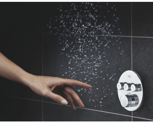 Douche avec élément de commande et main sous jet d''eau sur fond sombre