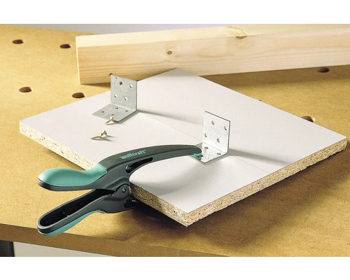 Pièce fixée avec équerre, vis et serre-joint à une main