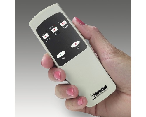 Une main tient une télécommande avec des boutons pour contrôler les niveaux de puissance.