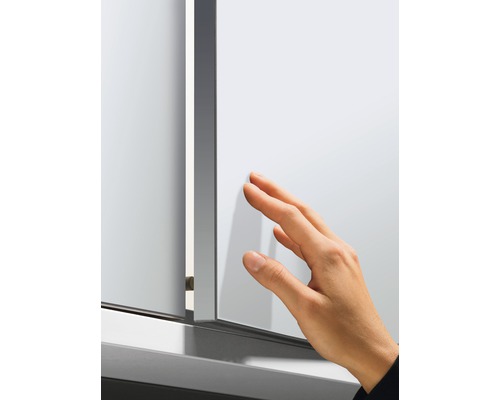 Une main touche une armoire de toilette