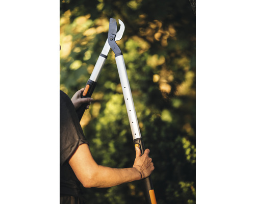 Personne tenant une cisaille à branches à long manche