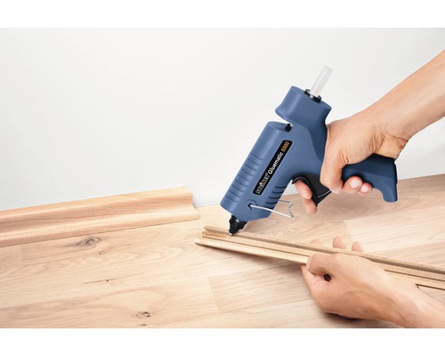 Pistolet à colle chaude en train de coller des baguettes en bois