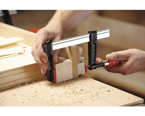 Holzbearbeitung mit einer Schraubzwinge zum Fixieren von Holzteilen.
